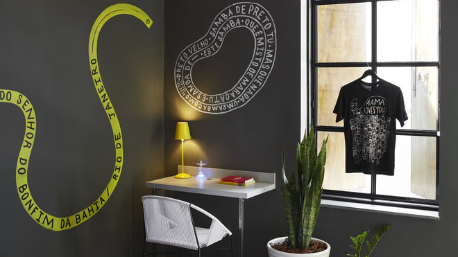 En jaune et noir, la décoration des chambres fait la part belle aux graffitis et messages. Un petit coin bureau agrémente l’espace.