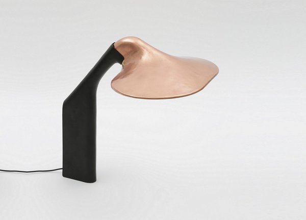 La base et l’abat-jour sont au départ de simples feuilles de métal martelées à la main puis ressoudées en formant des courbes et des replis. Lampe de table, cuivre formé et poli, plexiglas diffusant, pied en tôle d'acier et contrepoids en acier thermolaqués, éclairage LED, L.40 x P. 29 x H. 40 cm, 1600 €, fabrication à la commande, 10 exemplaires numérotés et poinçonnés.