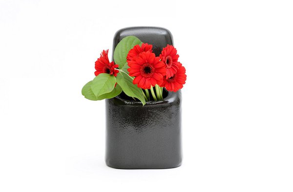 Un patron de tôle est formé et martelé pour s’arrondir et dessiner une forme sculptée, un volume doux qui enveloppe le bouquet. Vase, tôle d’acier, résine d'étanchéité, peinture à effet martelé, L. 18 x P. 11 x H. 31 cm, 320 €. Fabrication à la commande, 20 exemplaires numérotés et poinçonnés.