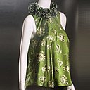 Franges pompons et glands , le pompon habituellement se dresse au sommet d'un bonnet, ici ils ornent le décolleté d'une blouse en soie.