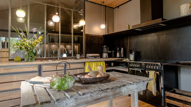 La Grange de Gazelle. La cuisine est un espace convivial et fonctionnel, équipé d’une baie vitrée de type industriel et d’une cuisinière à l’ancienne. La Grange de Gazelle. La cuisine est un espace convivial et fonctionnel, équipé d’une baie vitrée de type industriel et d’une cuisinière à l’ancienne.