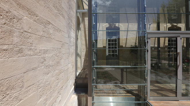 La légèreté de la charpente métallique de l’extension s’ajoute à la transparence des éléments vitrés magnifiant la lumière du Sud qui vient lécher la façade en pierre.