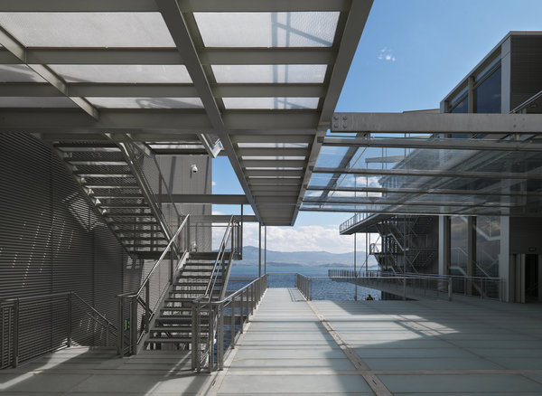 Une série de passerelles légères en acier et en verre séparent les deux volumes arrondis du bâtiment et crée un espace de circulation dessinant une sorte de place publique intermédiaire.