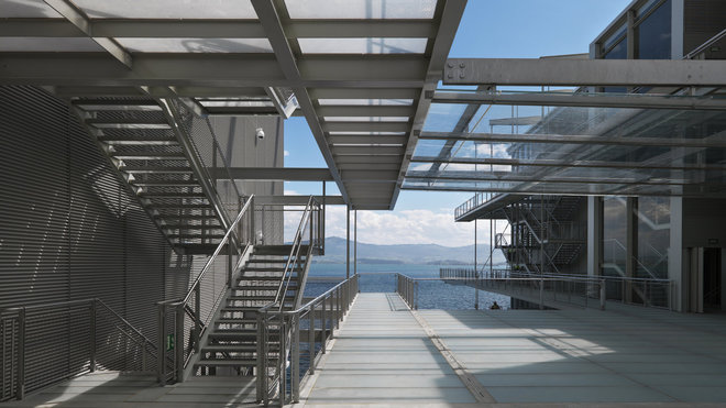 Une série de passerelles légères en acier et en verre séparent les deux volumes arrondis du bâtiment et crée un espace de circulation dessinant une sorte de place publique intermédiaire.