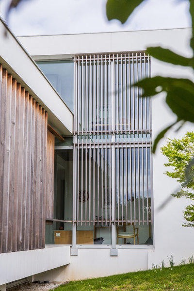 Au sud, les menuiseries en aluminium Technal sont rehaussées de claustras en bois qui rythment les façades de la villa et font office de brise-soleil et brise-vue.