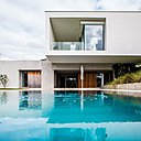 A l’ouest, les chambres parentales donnent sur la piscine que l’on aperçoit à travers trois baies coulissantes Soleal (Technal).