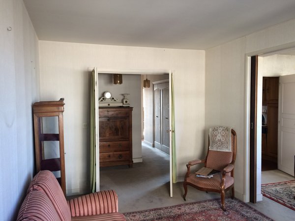 Avant : un salon avec une entrée séparée et des portes qui encombrent l’espace.