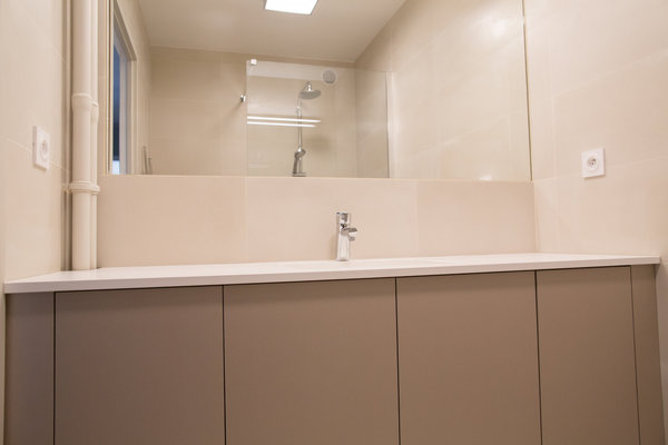 Sous le plan vasque, un rangement maximisé en mélaminé de couleur taupe à l’aspect métallisé (Egger), réalisé sur mesures par Flora Auvray.