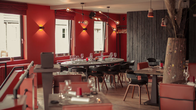 A droite, un vase monumental émaillé de surprenantes vignettes en cuir coloré, impose sa forme de baobab et offre son bouquet végétal évoquant de lointains horizons. Sur les murs, le dessin d’un faisceau d’appliques géométriques design.