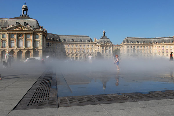 Le Miroir d’Eau devant la place de la Bourse à Bordeaux qui crée un brouillard et un renversement du paysage et du ciel au sol.