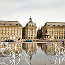 Installation des Bancs Nuages en acier peint sur le Miroir d’Eau qui offre un renversement du paysage avec la possibilité de s’asseoir l’intérieur même du ciel par le jeu du miroir d’eau. Création Pablo Reinoso.