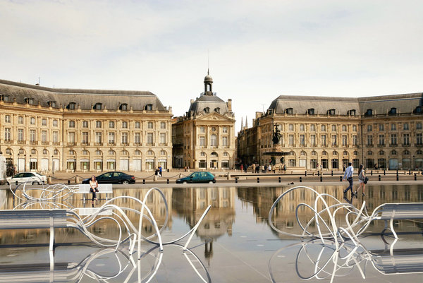Installation des Bancs Nuages en acier peint sur le Miroir d’Eau qui offre un renversement du paysage avec la possibilité de s’asseoir l’intérieur même du ciel par le jeu du miroir d’eau. Création Pablo Reinoso.