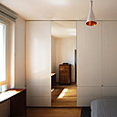 La chambre après : un grand rangement doté d’un miroir avec des placards profonds et des tiroirs en partie basse qui file sur l’intégralité du mur Ouest.