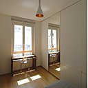 La chambre après : un petit bureau a été installé sous la fenêtre. La porte battante entre la pièce de jour et celle de nuit a été supprimée et remplacée par un panneau coulissant intégré dans la double cloison pour faciliter la communication et gagner de la place.