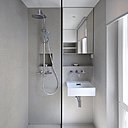 A gauche, la salle de bains avant : un espace qui appartient à un autre temps avec une tuyauterie apparente inesthétique et des équipements et des matériaux vieillots. A droite, la salle de bains après : un espace design et épuré avec un rangement fermé doté d’un miroir en façade, au-dessus du lavabo. Une tablette et une niche de rangement malignes et pratiques pour les produits de toilette de tous les jours.