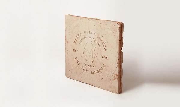 Tuile en merdacotta (bouse de vache) mise au point en Italie par l’entrepreneur agricole Ginantonio Locatelli avec un groupe de chercheurs milanais et l’architecte milanais Luca Cipelleti. Cette substance naturelle offre notamment des propriétés intéressantes en isolation. Un service de table (assiettes creuses, plates, carafe, tasse, saladier, bol) a été aussi confectionné dans cette matière. The Shit Museum, 2016.