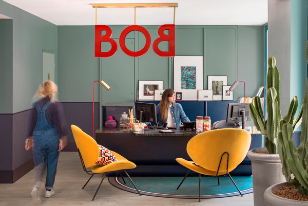 Dans la zone d’accueil, les touches fruitées des sièges et les murs en deux teintes rappellent la décoration d’un appartement privé d’aujourd’hui.