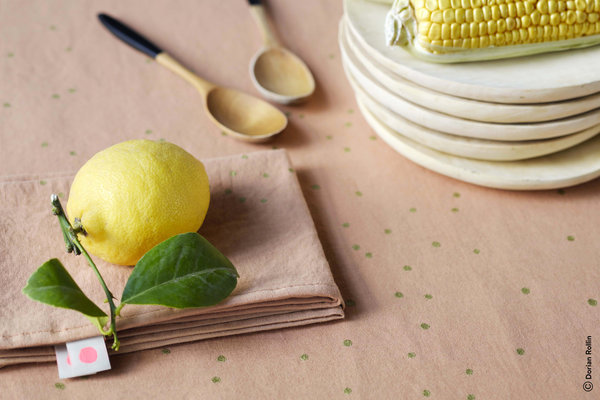 Nappe et serviette Na Lina coloris Litchi avec pluie de pois or, en métis (lin et coton), lavable en machine à 40°. Nappe en 160 x 160 cm et 160 x 250 cm. Serviette, 40 x 40 cm. Création La Cerise Sur Le Gâteau.