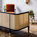 Le dossier du canapé met en exergue le beau travail du cannage, dans une version moderne et raffinée.