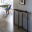 A gauche, console Halo en acier galvanisé et liège pour usage intérieur seulement (H 75 x 100 x 30 cm), déclinée en 32 couleurs. Création Julie Gaillard. A droite, console Zef (H 75 cm) déclinée en 7 tailles de plateau. Existe aussi en version avec tiroir, pieds droits ou effilés. Création Luc Jozancy.