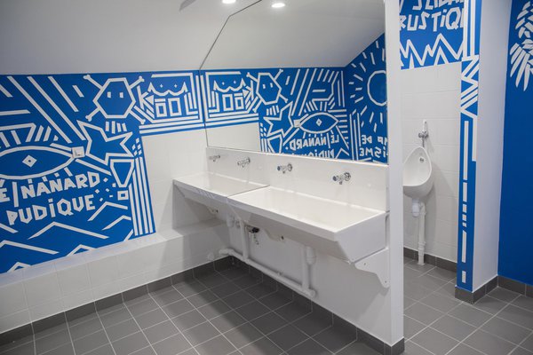 Dans les toilettes, une fresque bicolore où la géométrie explose.