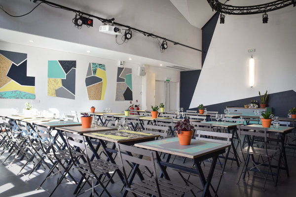La salle de restaurant se transforme en salle de concert, le soir venu. Tous les meubles réalisés spécialement pour le lieu ont été valorisés par des jeux de couleurs et de contrastes selon une gamme de formes géométriques propres à rationaliser le projet décoratif, le rendre cohérent et harmonieux.