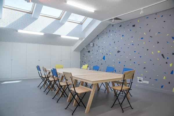 Les paillettes colorées que l’on retrouve derrière le bar, mais aussi dans l’atelier en fresque murale, s’affichent en clin d’œil au béton Preston, composé d’une mosaïque de petits cailloux, que l’on retrouve partout dans le quartier.