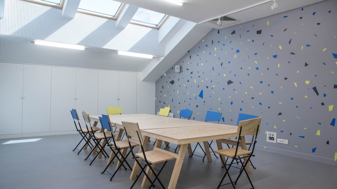 Les paillettes colorées que l’on retrouve derrière le bar, mais aussi dans l’atelier en fresque murale, s’affichent en clin d’œil au béton Preston, composé d’une mosaïque de petits cailloux, que l’on retrouve partout dans le quartier.