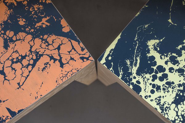 Gros plan sur les assises de chaises avec effets de marbrures réinventées par des couleurs décalées.