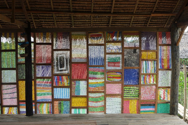 Le premier bâtiment d’Ikiko Village accueille une école et une recyclerie où sont collectés les sacs et bouteilles en plastique qui ravagent les plages, les rues et les parcs d’Isabel sur l’île de Leyte aux Philippines. Les produits de cette collecte, transformés en fils, servent à fabriquer de nouveaux objets et sont notamment utilisés dans la création de cloisons décoratives sur le site. Réalisation Christophe Cormy Donat, Isabel, île de Leyte, Philippines. Catégorie Lauréats, L’eau et l’urgence,.