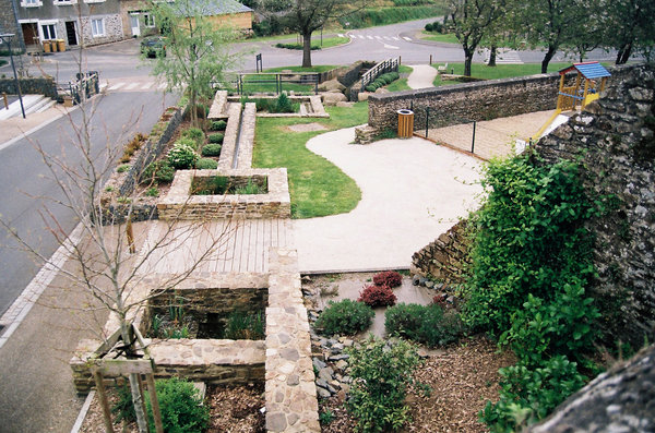 Ce ruisseau et chemin d’eau présente une maçonnerie en moellons de pierre, avec des plantes grimpantes disposées à la base des murs qui offrent une végétalisation verticale. Le parcours de l’eau qui passe par des rigoles, déversoirs, et bassins avec plantes aquatiques chutant dans un ruisseau nouvellement aménagé, est aussi valorisée par le son qu’il produit. Réalisation de l’architecte Christian Harlé et de la designer Arlette Harlé, Saint-Donan, France. Catégories Mentions pour le XIème Prix Européen d’Ar