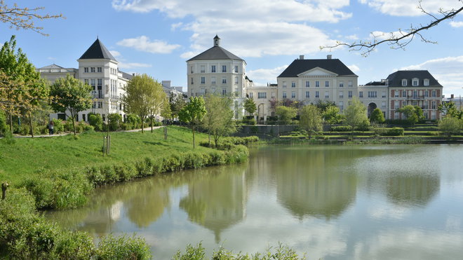 Dans le quartier du Lac du Val d’Europe, les architectes ont imaginé une entrée de ville inspirée des cités fortifiées du Nord de la France avec leurs profondes douves inondables. Les bâtiments se reflètent dans les eaux de deux bassins de régulation hydraulique. Réalisation collective sous la conduite de l’architecte Bernard Durand-Rival, France. Catégorie Nominés pour le XIème Prix Européen d’Architecture Philippe Rotthier 2017.