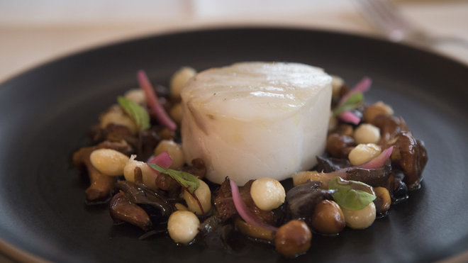 Cabillaud confit accompagné der haricots cocos et parsemé de noisettes.