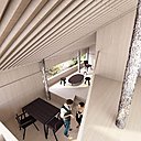 A l’intérieur, l’aménagement composé de meubles aux lignes simples et formes essentielles contraste avec l’esprit rustique des poteaux, véritables troncs bruts d’arbres qui percent les planchers. Le mobilier aux teintes sombres se démarque de l’enveloppe interne en bois clair.