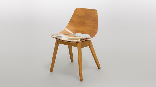 A la technique peu coûteuse et au confort très apprécié dans les années 1950, rare chaise Amsterdam avec coque à petite fenêtre en contreplaqué moulé habillé d’une simple galette de tissu et piètement bois, création A.R.P, éditée par Steiner.