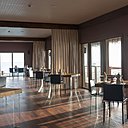 Le piètement en verre transparent de l’ensemble du mobilier dessine des formes éthérées comme en lévitation dans l’espace qui s’ouvre sur l’extérieur.