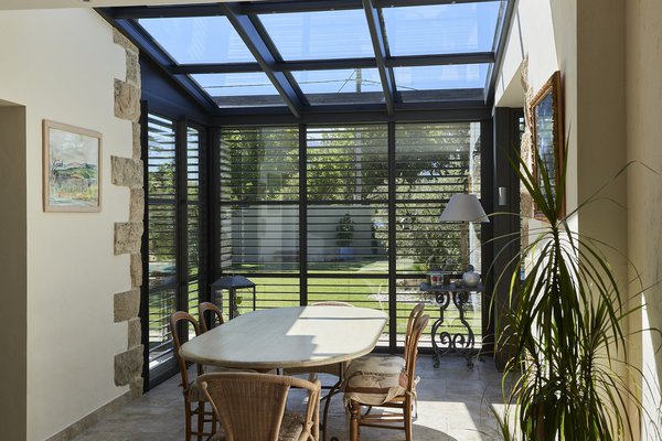 Dotée d’une toiture intégralement vitrée, l’extension est baignée de lumière naturelle. Elle profite de la couleur unique du ciel bleu de la Provence.