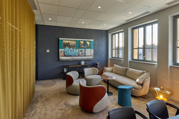 Chez Onepoint, une salle de détente et repos qui ressemble au salon d’un intérieur privé. Au sol, lampe Muffin de Brokis.