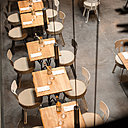 Les tables en bois brut et les chaises en acier laqué crème ont été dessinées par l’agence Exsud.