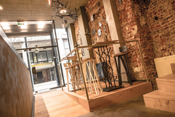 L’espace est traversant de la rue jusqu’au canal pour apporter un maximum de lumière ; les tables hautes sont installées pour un déjeuner sur le pouce et la cuisine/comptoir est ouverte.