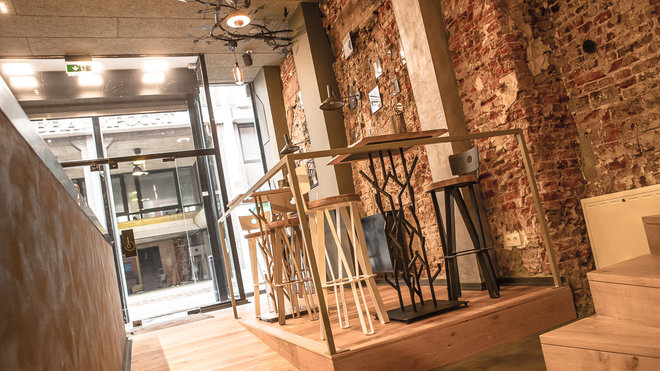 L’espace est traversant de la rue jusqu’au canal pour apporter un maximum de lumière ; les tables hautes sont installées pour un déjeuner sur le pouce et la cuisine/comptoir est ouverte.