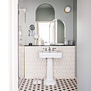 Sur le sol de la salle de bain un effet de treillis et cannage et sur les murs un dessin de grillage subtilement traduits dans les motifs des carrelages.