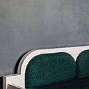 Sur la toile de fond d’un mur enduit à la chaux, un canapé contemporain réinterprétant de façon actuelle le mobilier de style aux formes douces et arrondies.