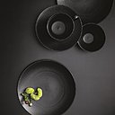 A gauche, collection Eclat avec finition or rose véritable sur les ailes des pièces. Assiettes plates, diam 28 cm, 25 €, l’une. Assiettes à dessert, diam 24 cm, 23 €, l’une. Coupelle, 19 cm diam, 20 €. Plateau vide-poches, 16 x 12 cm, 20 €. A droite, teinte pierre de lave et noir minéral en grès au relief satiné pour la collection Modulo nature. Assiettes de présentation, 31,5 cm diam , 20 €, l’une. Assiettes plates, 28 cm diam, 9,50 €, l’une. Saladier, 24 cm diam, 25 €. Le tout, chez Guy Degrenne.