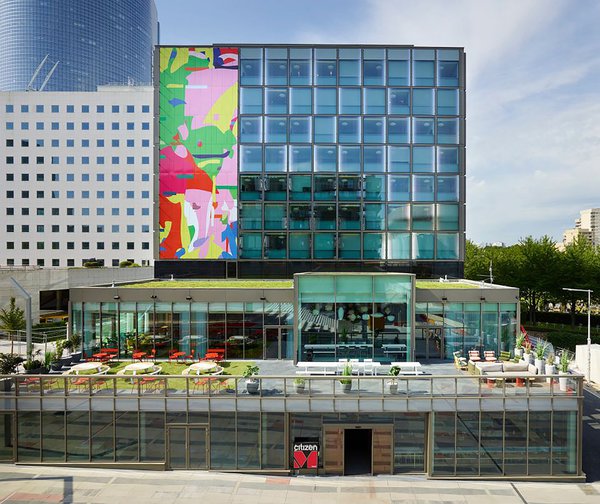 Côté nord du citizenM la Défense, la façade est ponctuée d’une œuvre abstraite aux couleurs vives, réalisée par le groupe d’artistes avaf et ponctuée de sérigraphies en dégradé chromé aléatoire sur des éléments verriers (technologie Ipachrome).