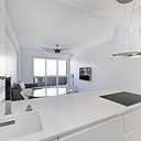 Les meubles de la cuisine font office de séparation de pièce. Plan de travail et vasque en Silestone. Robinetterie, Dornbracht. Dans le salon, suspension Vertigo, modèle taille moyenne, création Constante Guisset pour Petite Friture.