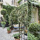 La cour arborée par Arôm « l’emblème du style bohème chic pour les jardins » avec balancelles et petits salon verts intimistes.