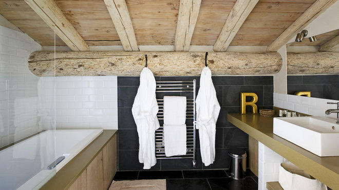 Carrelage noir et blanc et esprit graphique pour cette salle de bains où la poutraison d’origine sert de support pour les patères des peignoirs. Carrelage noir et blanc et esprit graphique pour cette salle de bains où la poutraison d’origine sert de support pour les patères des peignoirs.