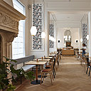 La cheminée conservée apporte une touche d’ancien. Les banquettes sur mesure houssées de tissu bleu ciel (Kvadrat) s’associent au bois blonds et à la lumière douce filtrée à travers des stores textiles.