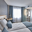 La salle de bains est séparée de la chambre par une cloison en verre dépoli qui laisse passer la lumière.